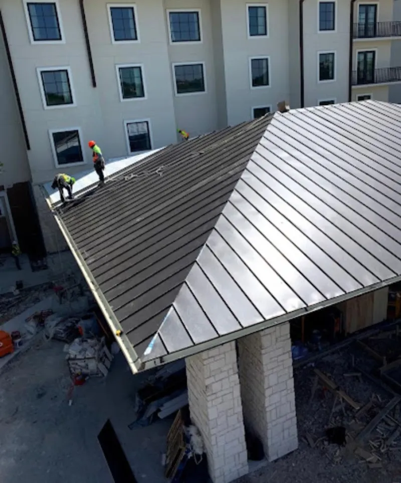 Crew installing standing seam metal roof panels on a commercial project in Walla Walla